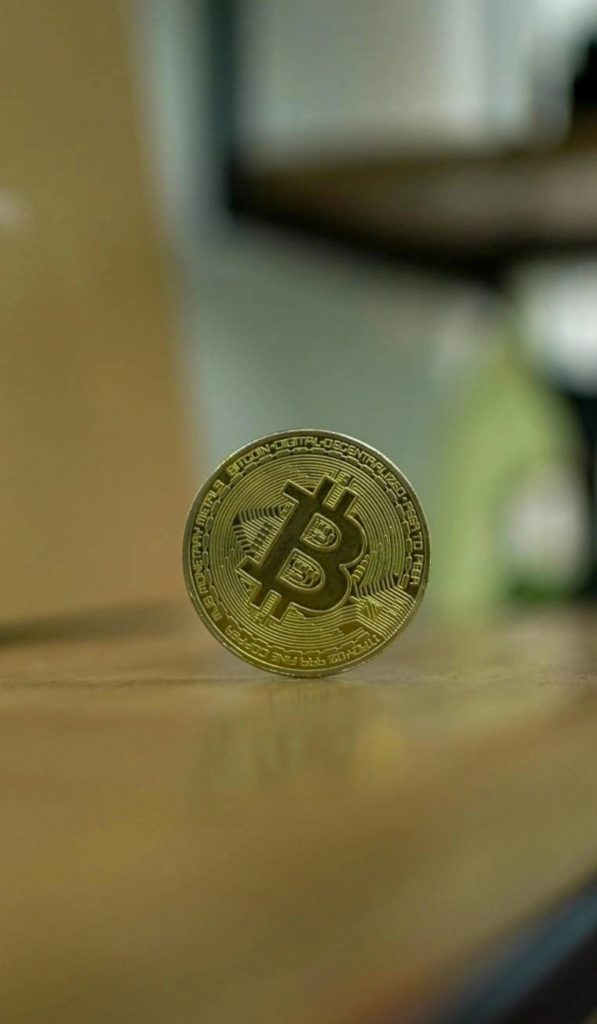close-up of a physical Bitcoin coin placed upright on a table symbolizing the transition from cryptocurrency speculation to blockchain-based fixed income