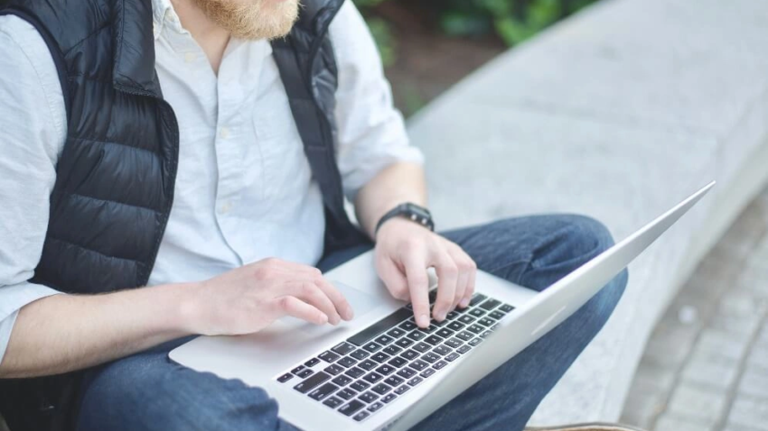 A professional working on a laptop outdoors